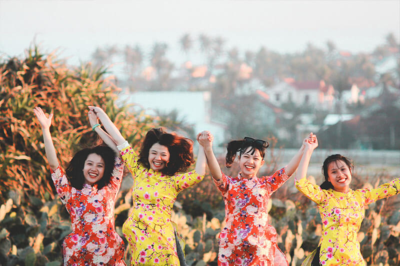 Women jumping with their hands linked together